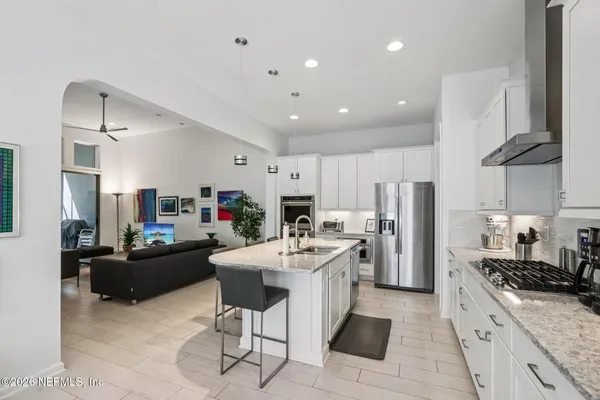 a kitchen with stainless steel appliances kitchen island granite countertop a refrigerator and a stove top oven