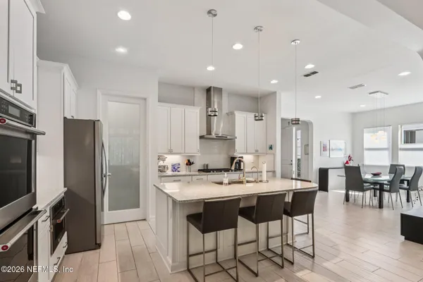a kitchen with stainless steel appliances kitchen island granite countertop a stove a sink a refrigerator and a refrigerator
