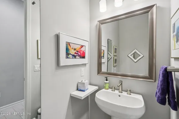 a bedroom with a bed and a lamp on dresser