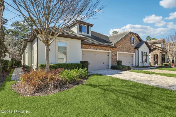 a front view of a house with a garden and plants