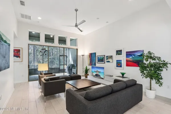a living room with furniture kitchen view and a potted plant