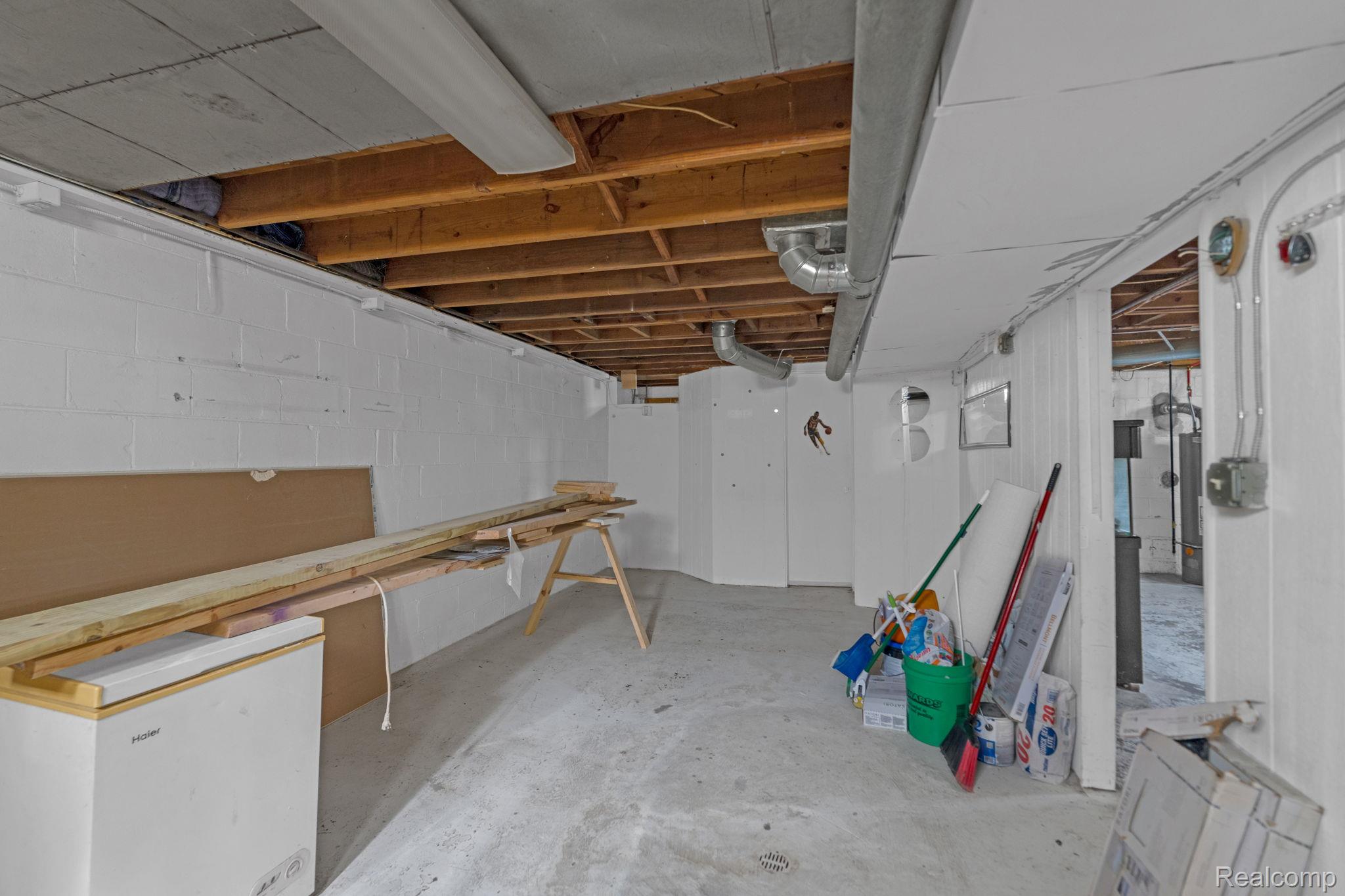 7641 Pelham Road Allen Park, MI 48101 - Photo 20 of 21 Unfinished basement area featuring exposed ceiling joists, concrete block walls, and a concrete floor
