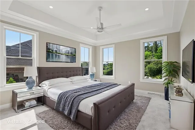a bedroom with a bed a potted plant on dresser and a window