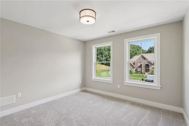 an empty room with a fan & a mirror