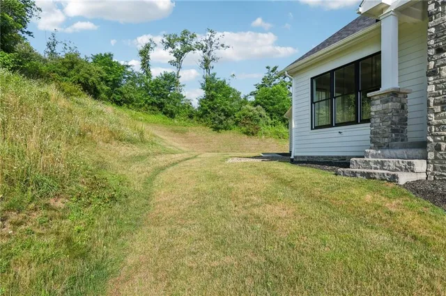 a front view of a house with yard and green space