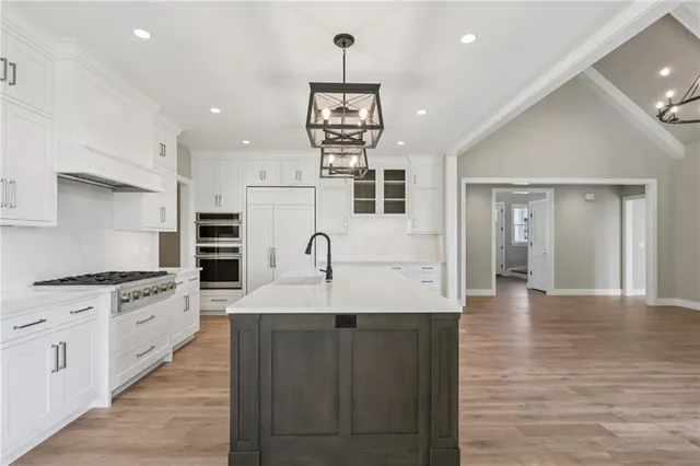 a large kitchen with stainless steel appliances kitchen island granite countertop a stove and a sink