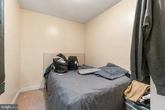 a bedroom with a bed and a refrigerator