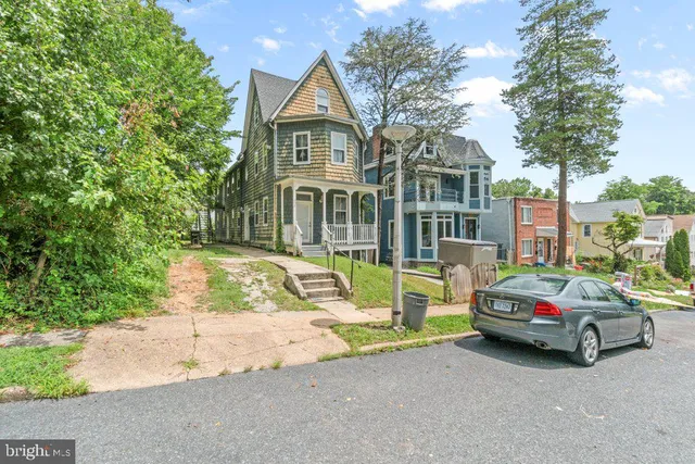 a car parked in front of a house with a yard