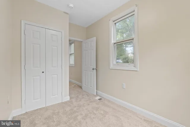 an empty room with windows and closet