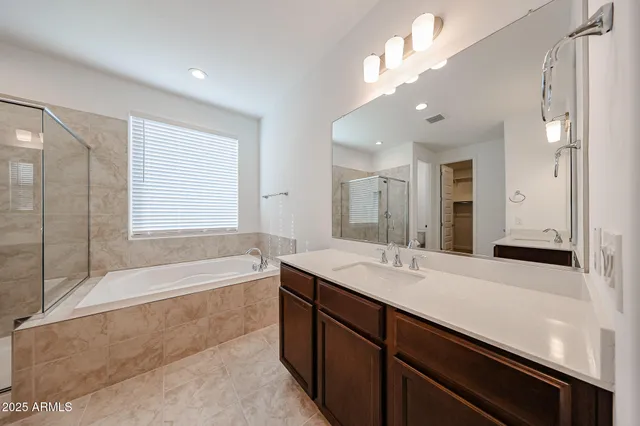 a spacious bathroom with a sink a large mirror and a bathtub