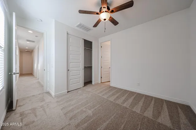 en empty room with closet and a ceiling fan
