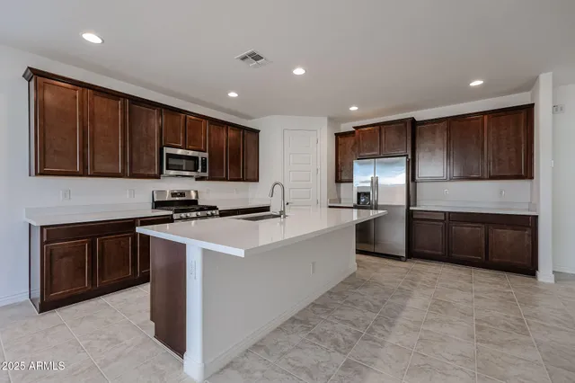 a kitchen with kitchen island granite countertop stainless steel appliances and sink