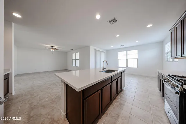 a kitchen with a stove a sink a microwave and a refrigerator