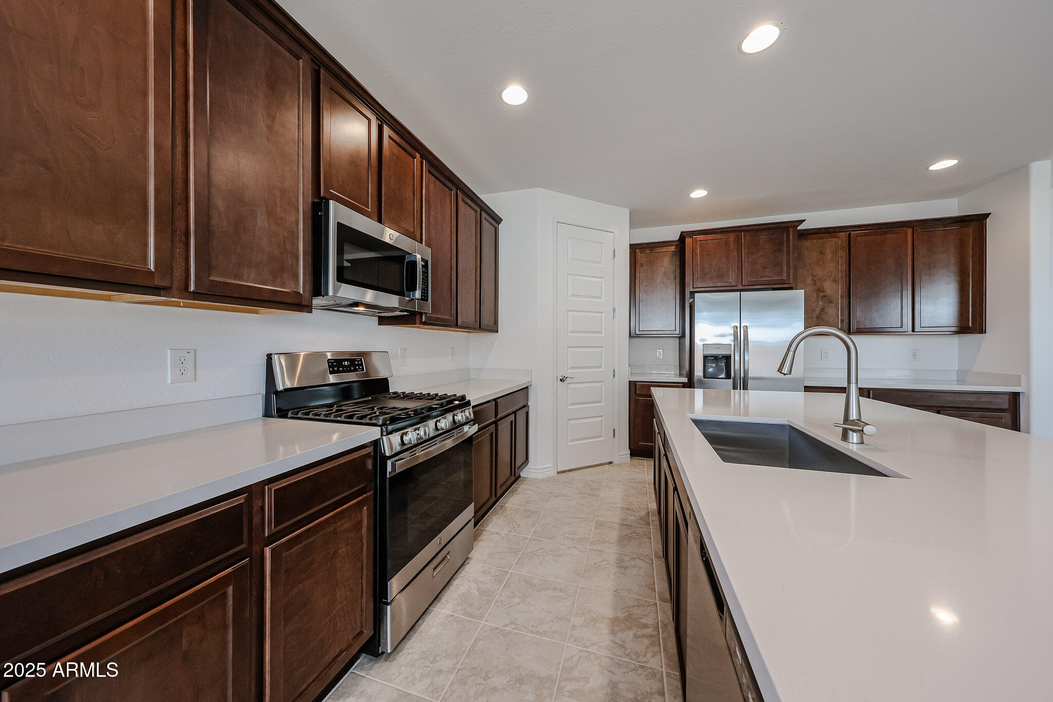 25128 North 171st Avenue Surprise, AZ 85387 - Photo 4 of 22 a kitchen with stainless steel appliances granite countertop a sink stove microwave and refrigerator
