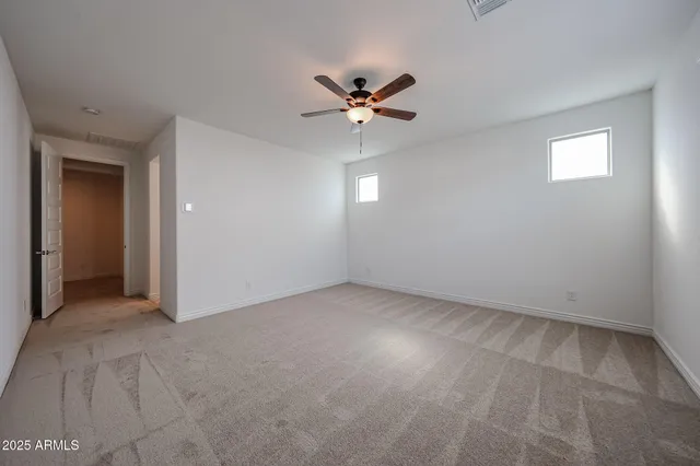 an empty room with closet and a ceiling fan