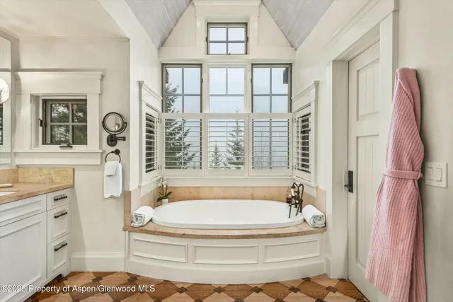 a bedroom with a bed couch and a large window