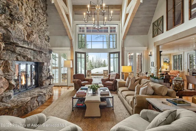 a living room with patio furniture and a chandelier