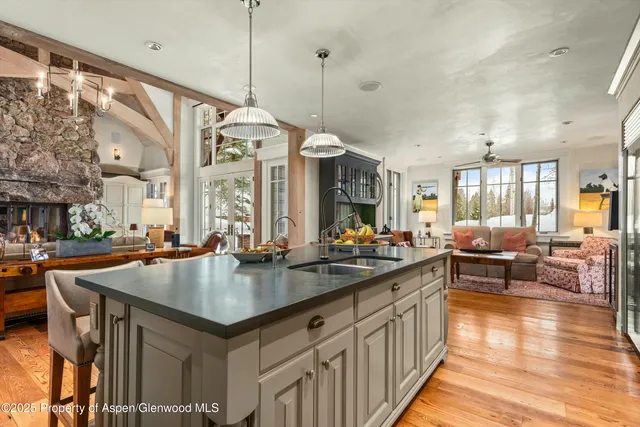a living room with furniture a wooden floor and a large window