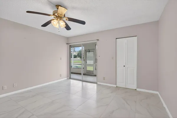 a view of an empty room with a chandelier fan