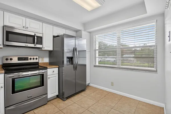 a kitchen with stainless steel appliances a stove a microwave and a window