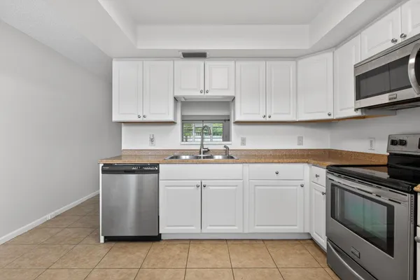a kitchen with stainless steel appliances granite countertop a sink and a stove