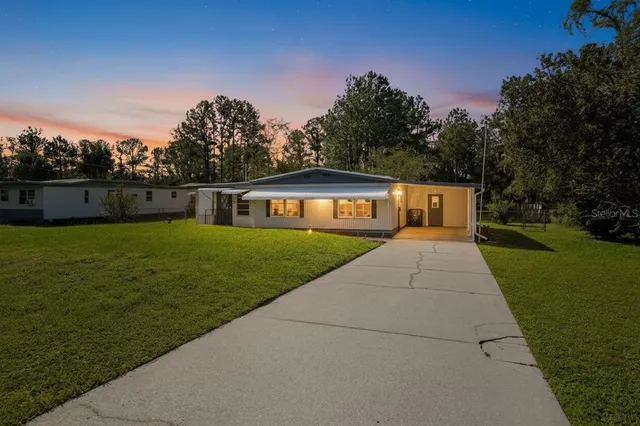 an empty room with wooden floor ceiling fan and windows