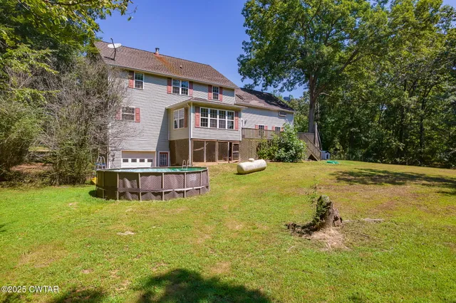 an aerial view of residential house with green space and mountain view in back