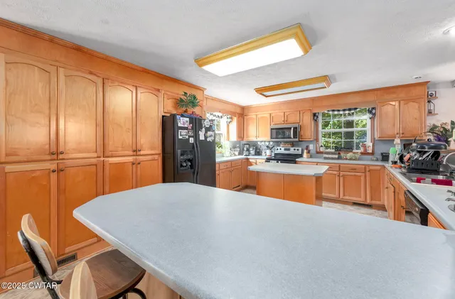 a kitchen with stainless steel appliances granite countertop a sink dishwasher and a refrigerator