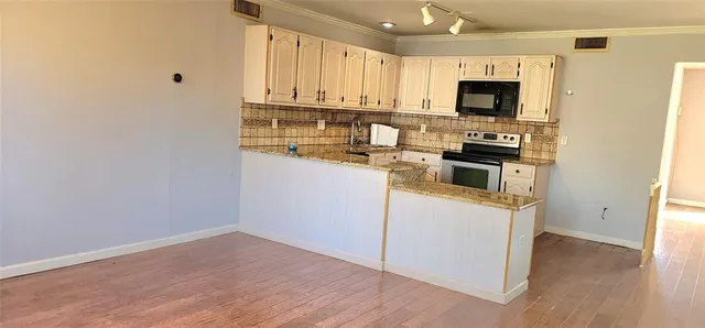 a kitchen with stainless steel appliances granite countertop a stove a sink and a microwave