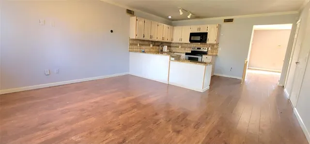 a kitchen with white cabinets and appliances