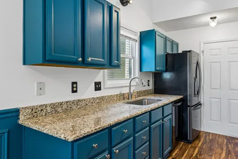 a kitchen with stainless steel appliances granite countertop wooden cabinets a refrigerator and a sink