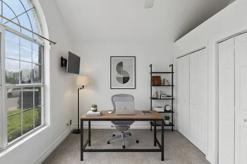 a view of a workspace with furniture and window