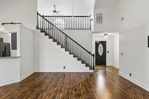 a view of a hallway with wooden floor and staircase
