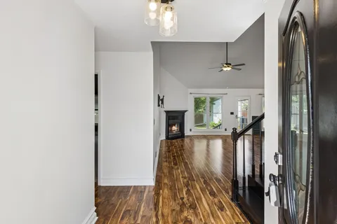 a view of a hallway with wooden floor and staircase