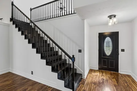 a view of hallway with wooden floor and stairs