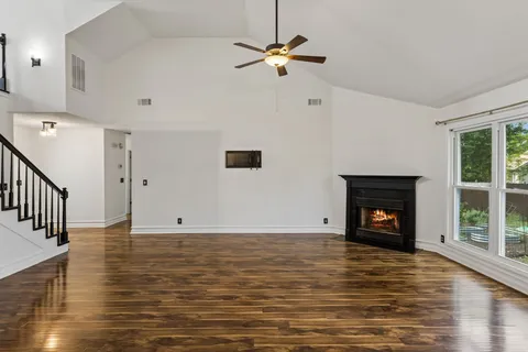 a view of an empty room with a fireplace and a window