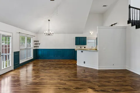 a view of a kitchen with wooden floor and a sink