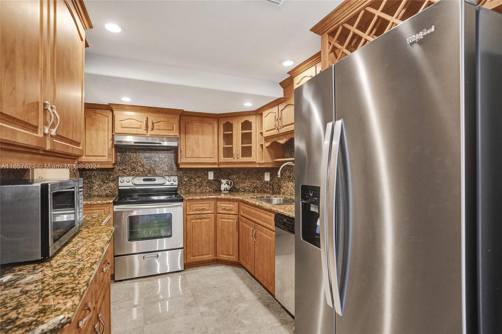 500 Bayview Drive, Unit PH20 Sunny Isles Beach, FL 33160 - Photo 15 of 41 a kitchen with stainless steel appliances granite countertop a refrigerator a stove and a sink with wooden floor