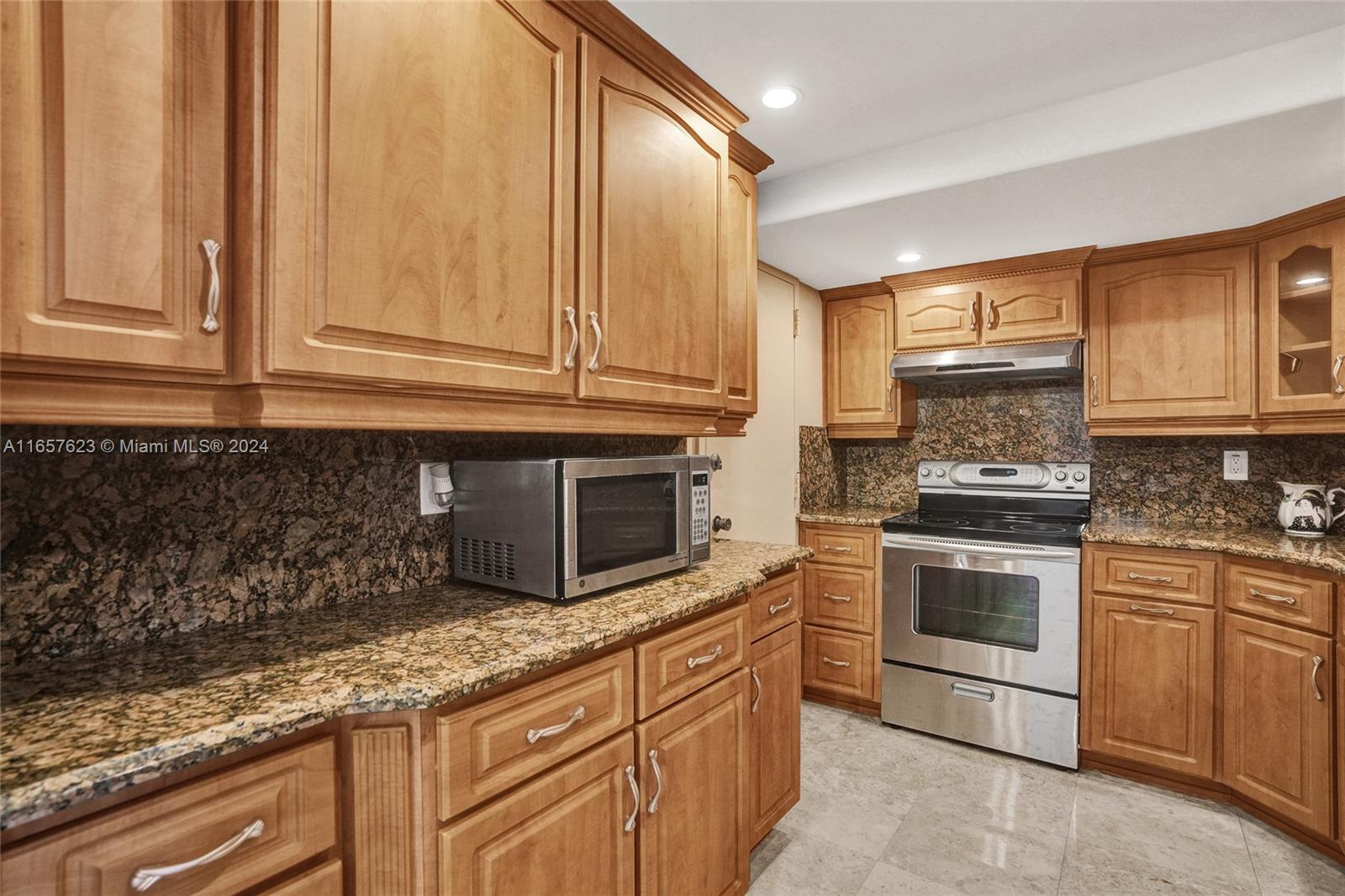 500 Bayview Drive, Unit PH20 Sunny Isles Beach, FL 33160 - Photo 16 of 41 a kitchen with granite countertop stainless steel appliances white cabinets granite counter tops and a wooden floors