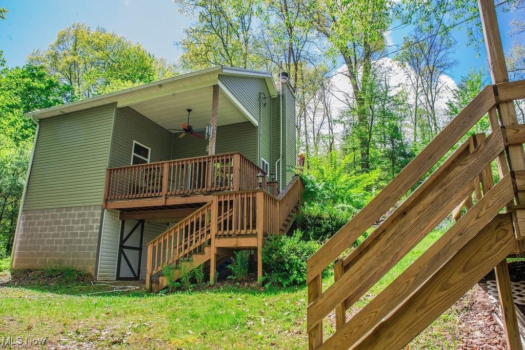 4254 Doral Road Southwest Carrollton, OH 44615 - Photo 39 of 46 Back of house with a wooden deck, stairway, a ceiling fan, a chimney, and a yard