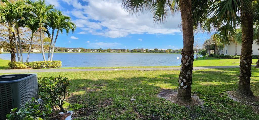 5005 Wiles Road, Unit 106 Coconut Creek, FL 33073 - Photo 3 of 19 a view of a lake with a big yard
