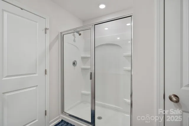 a bathroom with a glass shower door and a sink