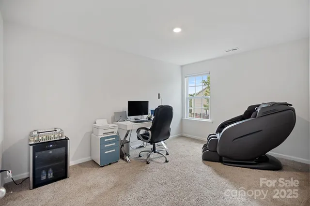 a view of a workspace with furniture and a window