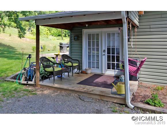 951 Old Clyde Road Clyde, NC 28721 - Photo 4 of 18 a view of a patio with table and chairs and floor to ceiling window
