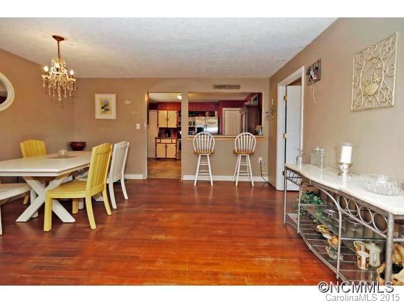 951 Old Clyde Road Clyde, NC 28721 - Photo 8 of 18 a view of dining room and livingroom with furniture wooden floor a rug and a chandelier