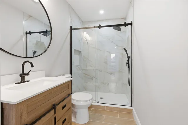 a bathroom with a sink mirror toilet and shower