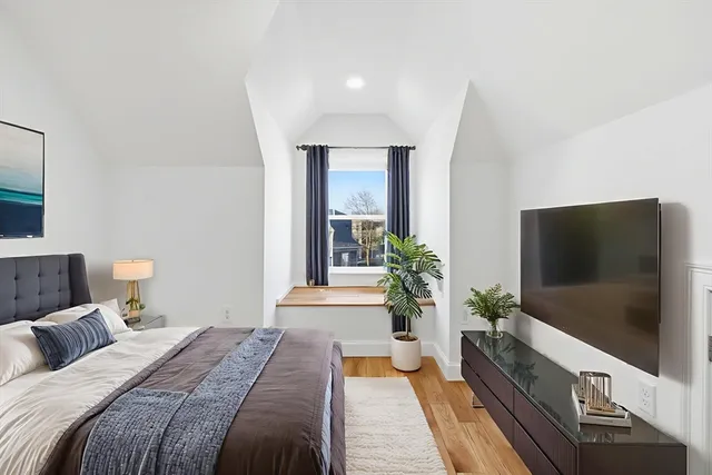 a spacious bedroom with a bed and a flat screen tv