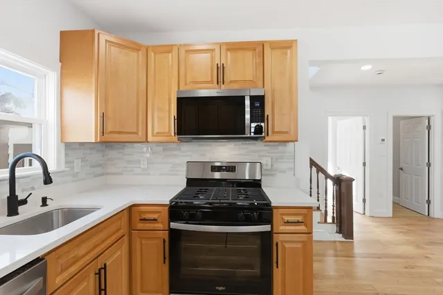 a kitchen with stainless steel appliances granite countertop a stove a sink and a microwave