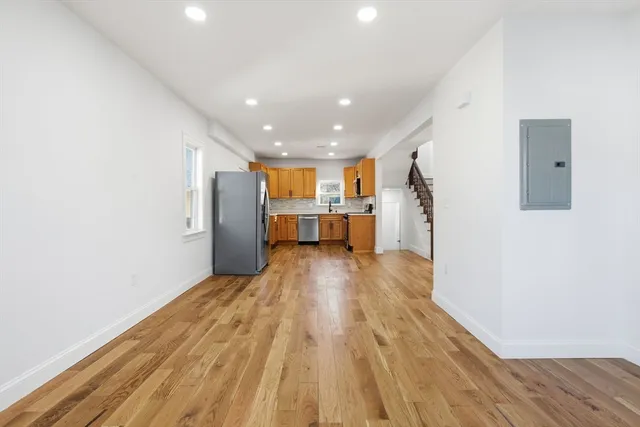 a view of empty room with wooden floor