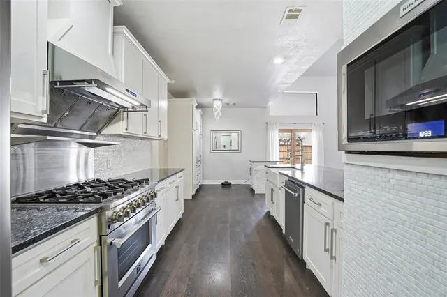a kitchen with stainless steel appliances a stove sink and cabinets